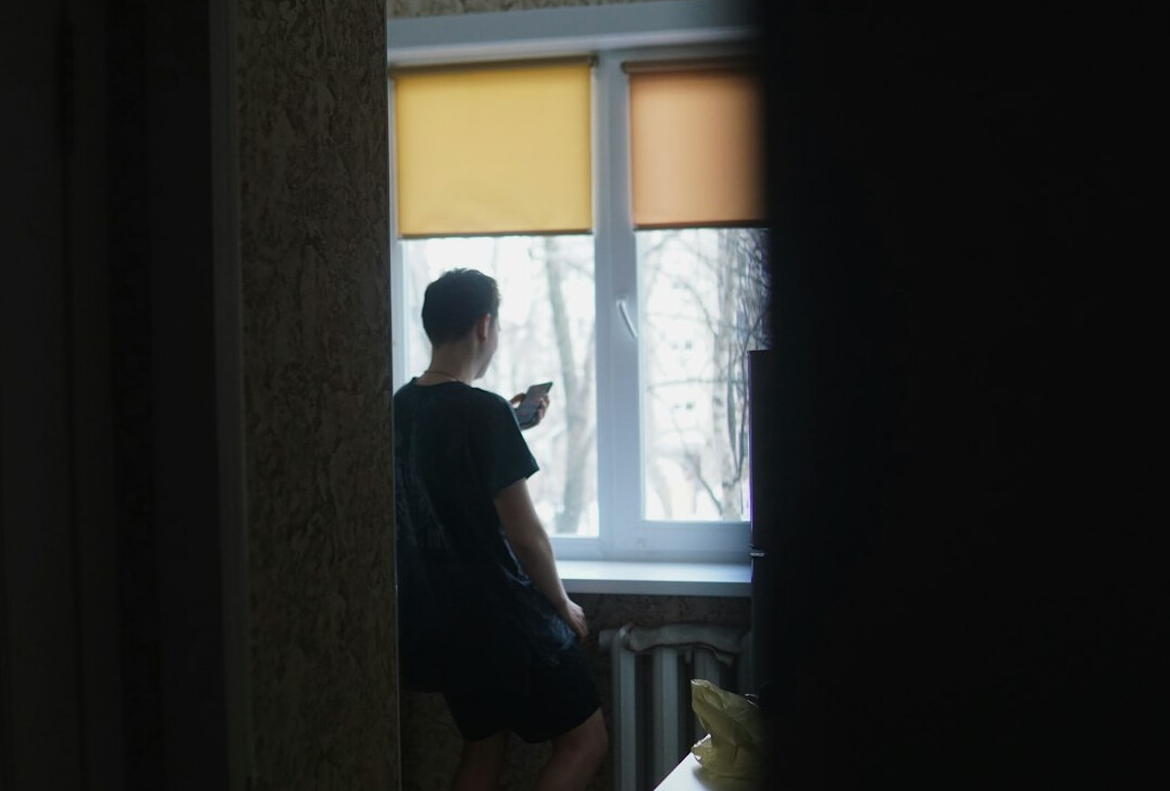 Person reading news on a tablet at home over the shoulder